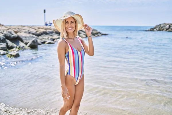 年轻的金发姑娘在海滩上戴着夏帽开心地笑着 — 图库照片