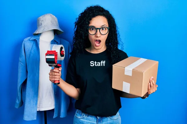 Young Hispanic Woman Curly Hair Wearing Staff Shirt Holding Cardboard —  Fotos de Stock