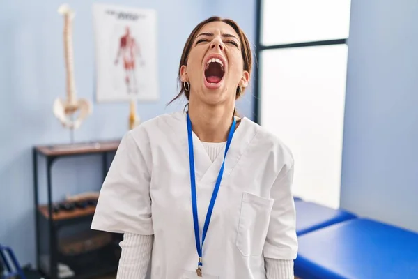Young Brunette Woman Working Pain Recovery Clinic Angry Mad Screaming — Stock Photo, Image