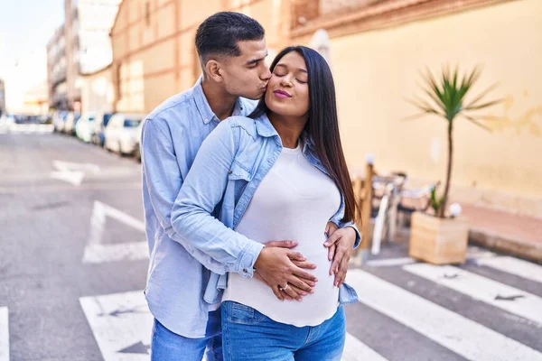 Young Latin Couple Expecting Baby Hugging Each Other Kissing Street — Zdjęcie stockowe