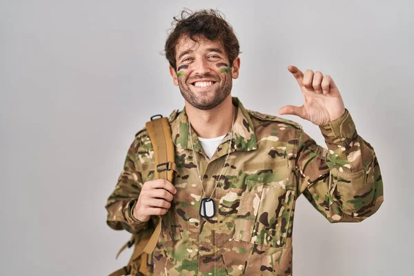 Spanskættede Unge Mann Med Kamuflasjeuniform Smilende Selvsikker Gest Med Håndtegnet – stockfoto