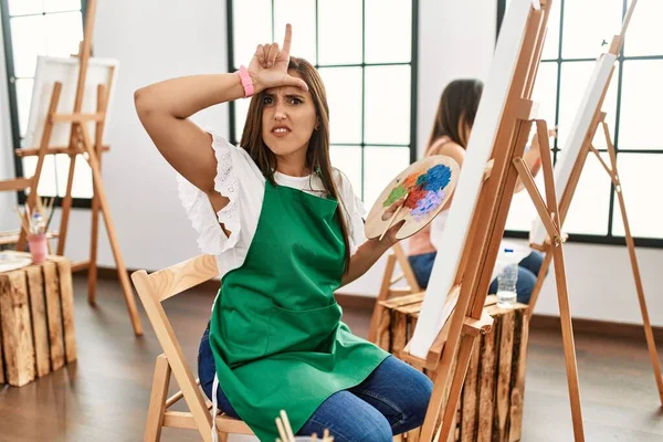 Młoda Latynoska Artystka Maluje Płótnie Pracowni Sztuki Nabijając Się Ludzi — Zdjęcie stockowe