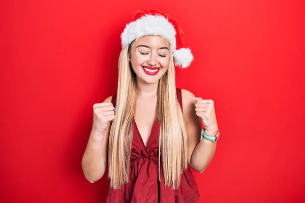 Young Blonde Girl Wearing Christmas Hat Excited Success Arms Raised — Stockfoto