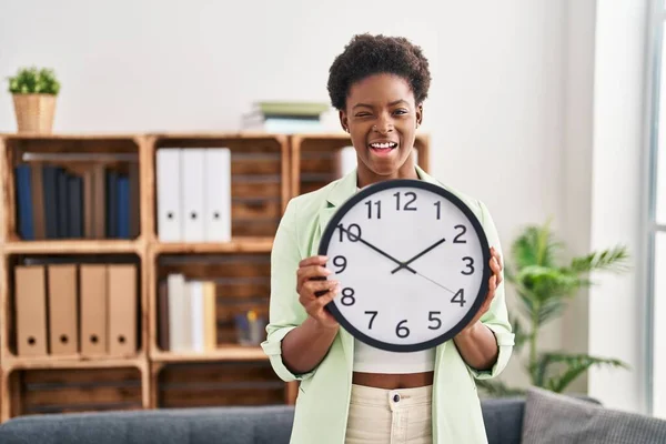 African American Woman Holding Big Clock Winking Looking Camera Sexy — Stockfoto