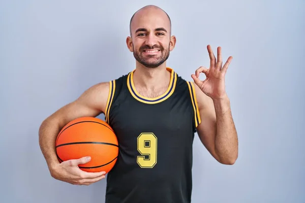 Mladý Plešatý Muž Plnovousem Basketbalové Uniformě Držící Míček Usmívající Pozitivně — Stock fotografie