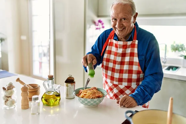 Ηλικιωμένος Χαμογελάει Αυτοπεποίθηση Ρίχνοντας Ρίγανη Στα Μακαρόνια Στην Κουζίνα — Φωτογραφία Αρχείου