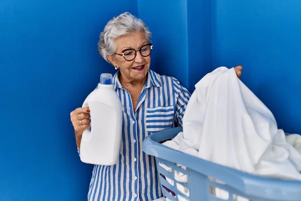 Senior Šedovlasá Žena Usměvavá Sebevědomě Drží Čisticí Prostředek Láhev Prádelně — Stock fotografie