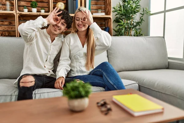 Mladý Krásný Pár Sedí Pohovce Doma Usměvavý Šťastný Dělá Znamení — Stock fotografie