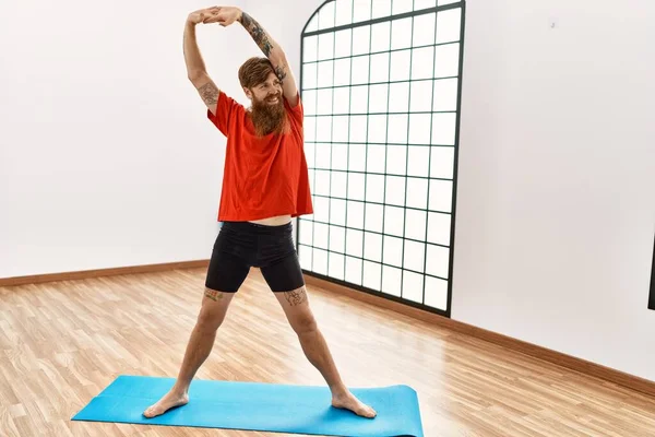 Ung Rödhårig Man Ler Tryggt Stretching Sportcenter — Stockfoto