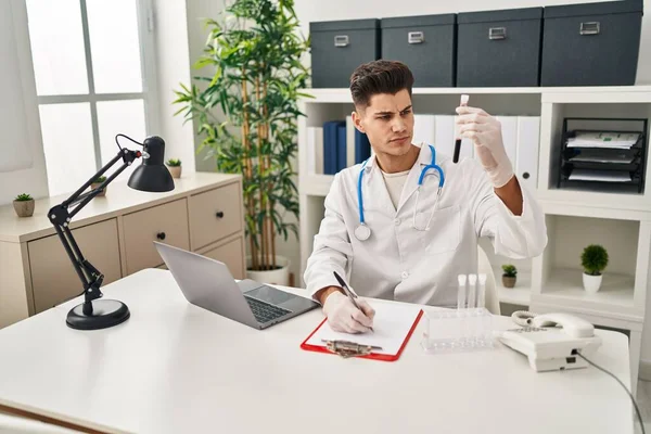 Jovem Hispânico Vestindo Uniforme Médico Analisando Tubo Sangue Clínica — Fotografia de Stock