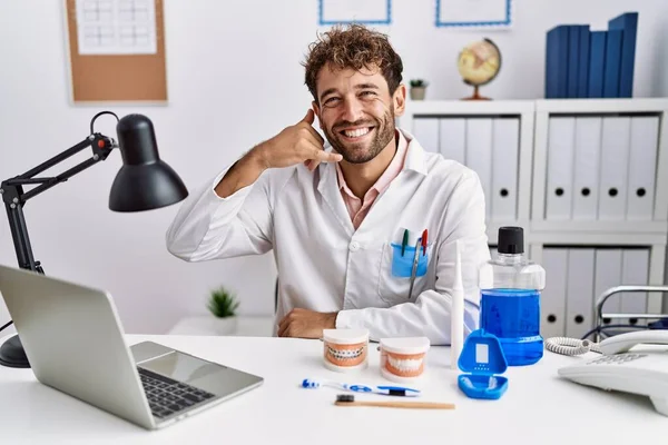 Jonge Spaanse Tandarts Werkt Medische Kliniek Glimlachend Doet Telefoongebaar Met — Stockfoto