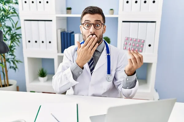 Handsome Hispanic Man Wearing Doctor Uniform Holding Prescription Pills Covering — Stock Photo, Image