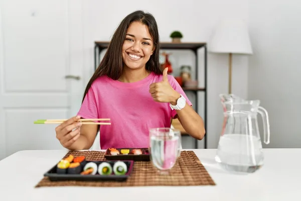 Young Brunette Woman Eating Sushi Using Chopsticks Doing Happy Thumbs — 图库照片