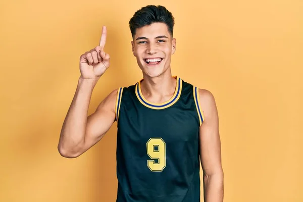 Young Hispanic Man Wearing Basketball Uniform Pointing Finger Successful Idea — стоковое фото