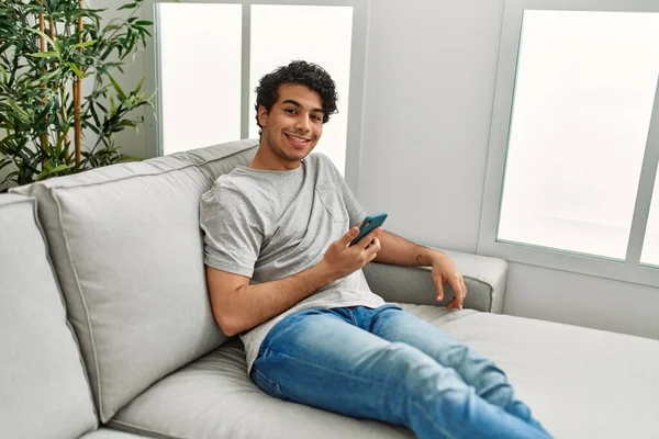 Joven Hombre Hispano Usando Smartphone Sentado Sofá Casa —  Fotos de Stock