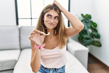 Görünmez hizalayan, ortodontik kafa karıştırıcı ve soru soran genç sarışın kadın. Şüpheyle kararsız, kafa kafaya düşünerek. Düşünceli kavram. 