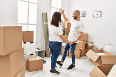 Genç İspanyol çift gülümsüyor yeni evinde mutlu dans ediyor.