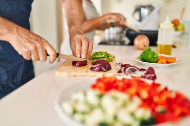 Orta yaşlı İspanyol çift mutfakta yemek pişiriyor.