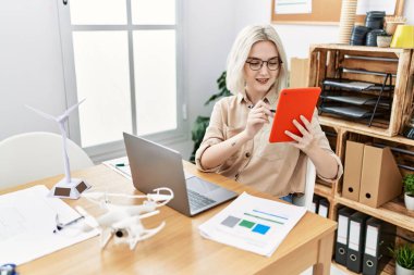 Young caucasian woman using touchpad working at office