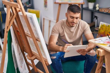 Genç İspanyol ressam resim stüdyosunda kendine güvenen çizimler yapıyor.