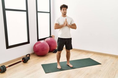 Genç İspanyol adam spor merkezinde yoga eğitimi alıyor.
