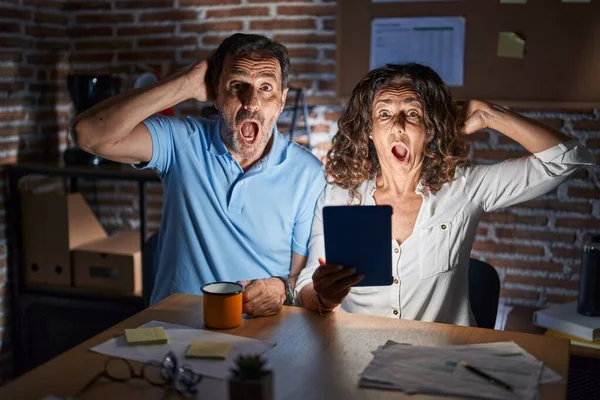 Middle Age Hispanic Couple Using Touchpad Sitting Table Night Crazy — Foto Stock
