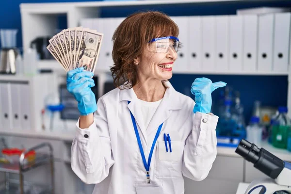 Женщина Средних Лет Работающая Лаборатории Учёных Держит Деньги Указывая Пальцем — стоковое фото