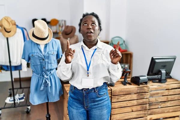 Young African Woman Working Manager Retail Boutique Amazed Surprised Looking — Stockfoto