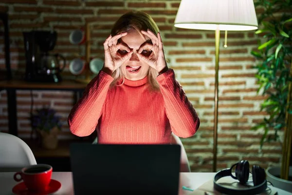 Blonde Woman Using Laptop Night Home Doing Gesture Binoculars Sticking — Stockfoto