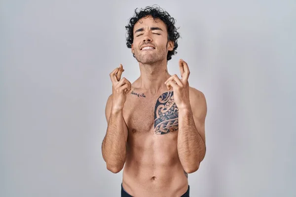 Hispanic Man Standing Shirtless Gesturing Finger Crossed Smiling Hope Eyes — Foto Stock