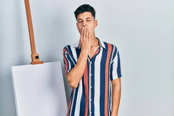 Young Hispanic Man Standing Close Empty Canvas Bored Yawning Tired — Φωτογραφία Αρχείου
