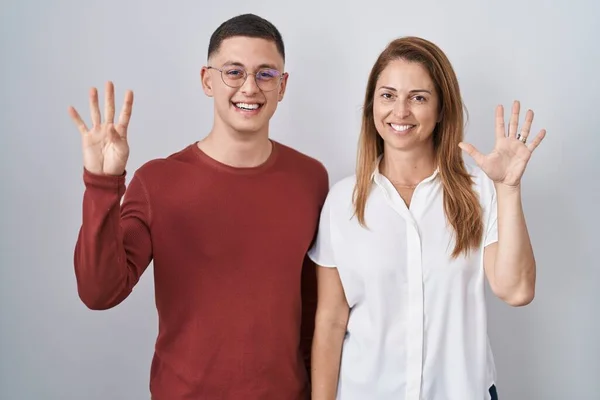 Mother Son Standing Together Isolated Background Showing Pointing Fingers Number — Stockfoto