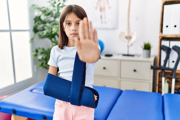 Young Hispanic Girl Wearing Arm Sling Rehabilitation Clinic Open Hand — Stock fotografie