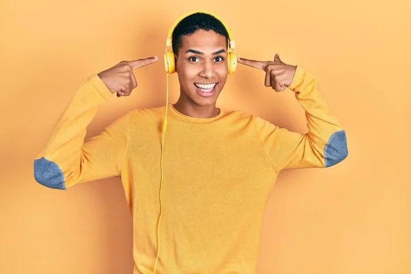 Young African American Guy Listening Music Using Headphones Smiling Pointing — Stock Photo, Image