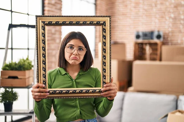 Young Hispanic Woman New Home Holding Empty Frame Depressed Worry — Stock Photo, Image