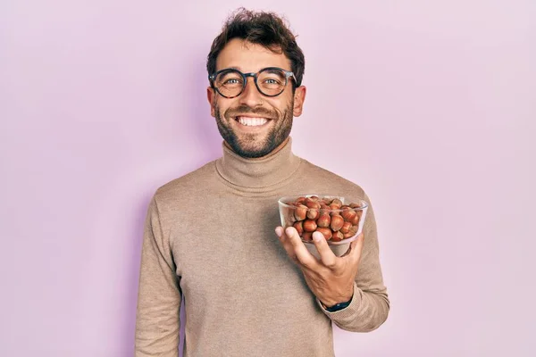 Homem Bonito Com Barba Segurando Tigela Castanhas Olhando Positivo Feliz — Fotografia de Stock