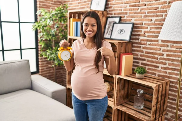 Young Pregnant Woman Holding Alarm Clock Due Date Pointing Finger — ストック写真