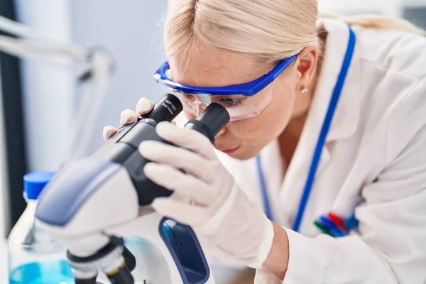 Mujer Rubia Joven Vistiendo Uniforme Científico Usando Microscopio Laboratorio —  Fotos de Stock
