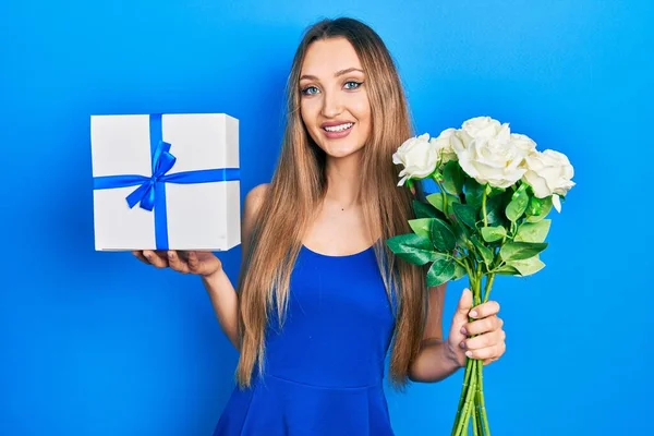 Joven Chica Rubia Sosteniendo Regalo Aniversario Ramo Flores Sonriendo Con — Foto de Stock