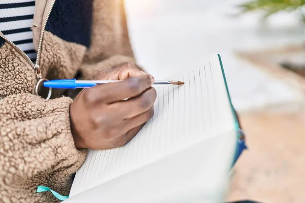 Sokakta deftere yazan Afrikalı Amerikalı kadın.