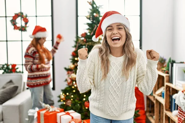 美しいカップルで家に立つクリスマスツリーによって叫んで誇りに思って勝利と成功を祝う非常に興奮して腕を上げ — ストック写真