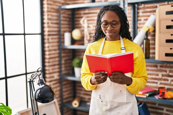 African American Woman Artist Smiling Confident Reading Book Art Studio — Stok fotoğraf