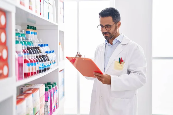 Young Hispanic Man Pharmacist Smiling Confident Writing Document Pharmacy — Stock Photo, Image