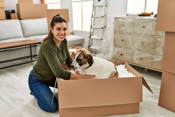Young woman smiling confident playing with dog at home