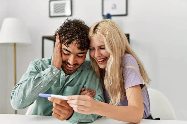 Casal Jovem Sorrindo Feliz Olhando Resultado Teste Grávida Casa — Fotografia de Stock