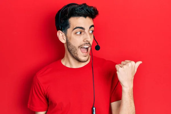Young Hispanic Man Wearing Call Center Agent Headset Pointing Thumb — Stock Photo, Image