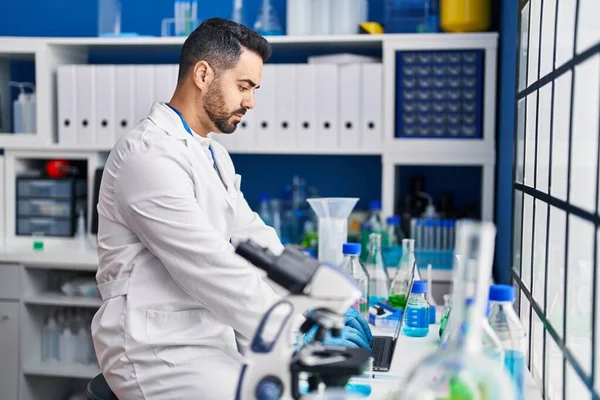 Young Hispanic Man Scientist Using Laptop Laboratory — Stock fotografie