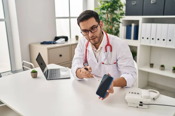 Joven Hombre Hispano Vistiendo Uniforme Médico Mostrando Aplicación Teléfono Inteligente — Foto de Stock