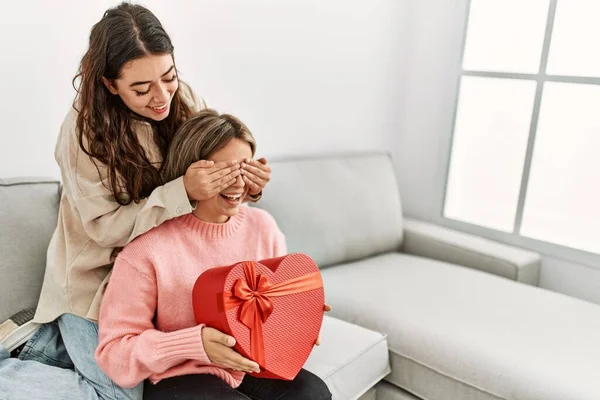 Mujer Joven Sorprendiendo Novia Con Regalo San Valentín Casa —  Fotos de Stock