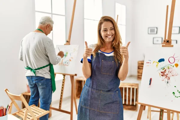 Hispanic Woman Wearing Apron Art Studio Success Sign Doing Positive — Φωτογραφία Αρχείου